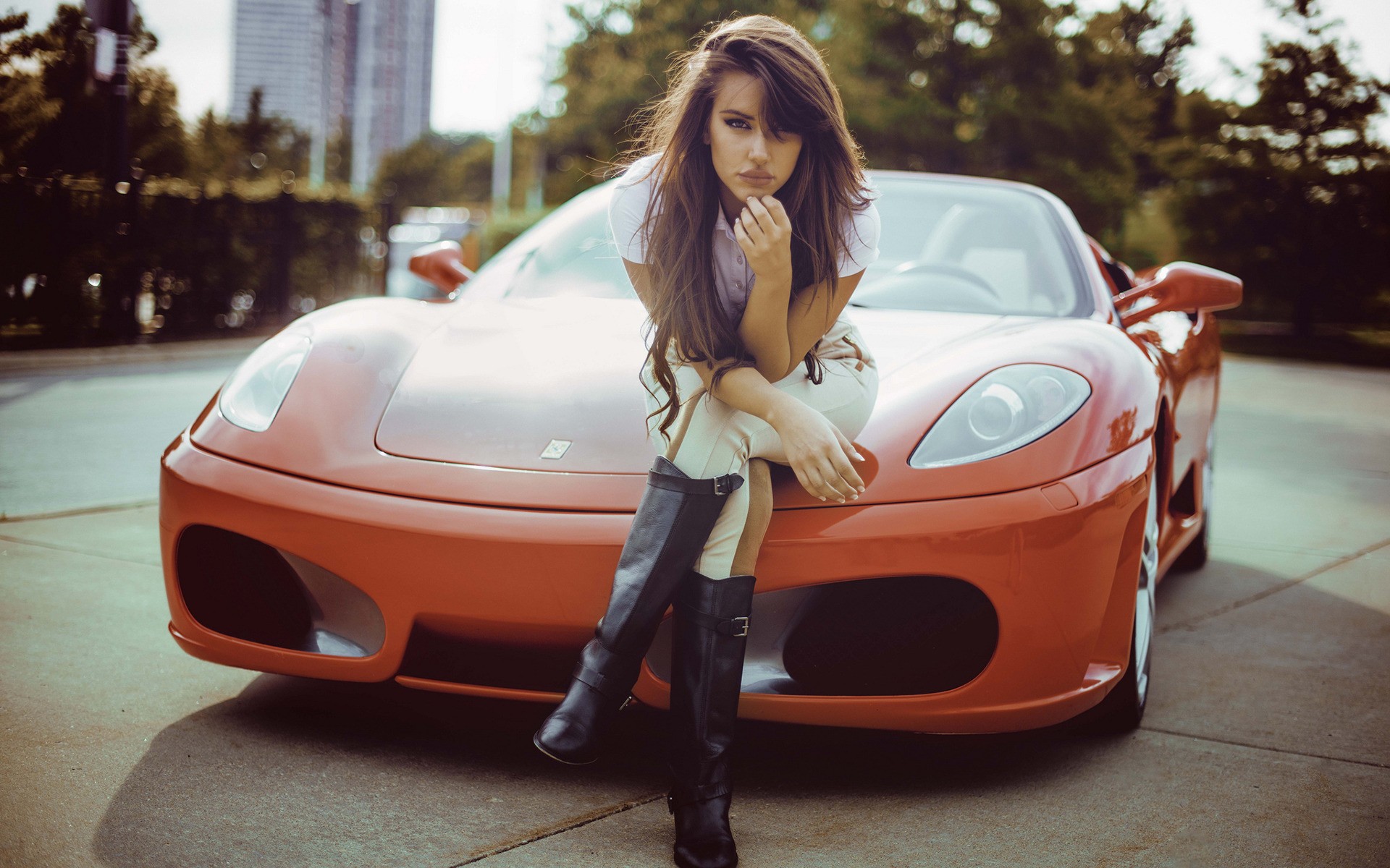 Girls Girl sitting on the hood of the orange Ferrari