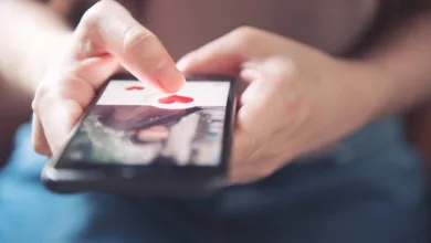 womans finger pressing on a heart on a dating app